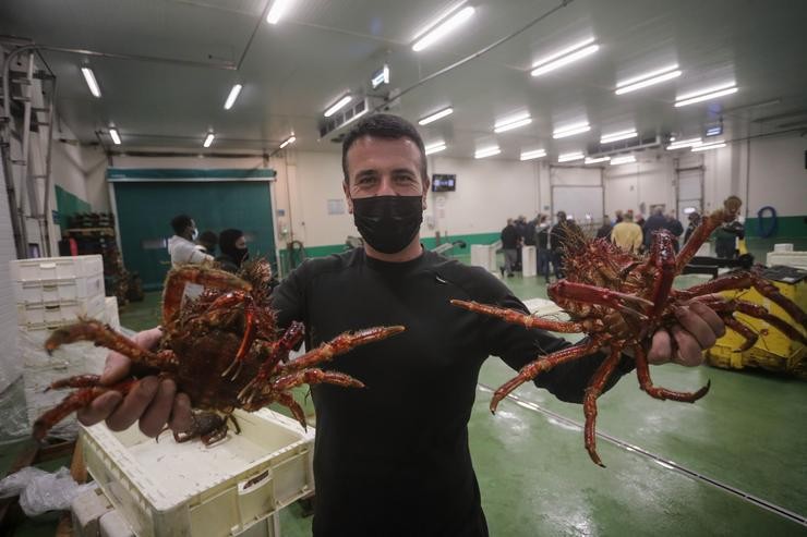 Un pescadero sostén dous cangrexos na lonxa de Burela, a 23 de decembro de 2021, en Lugo, Galicia, (España). Como cada ano, a lonxa de Burela acolle a última poxa de marisco previa á Noiteboa. É nesta poxa cando o marisco alcanza may. Carlos Castro - Europa Press / Europa Press