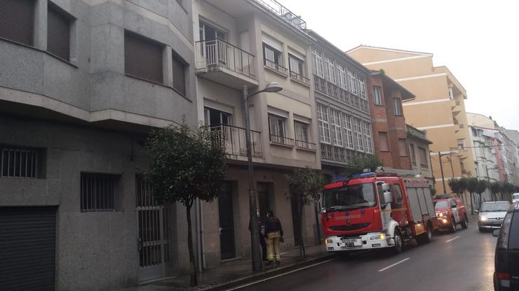 Bombeiros tentando apagar un lume nun edificio de Monforte 