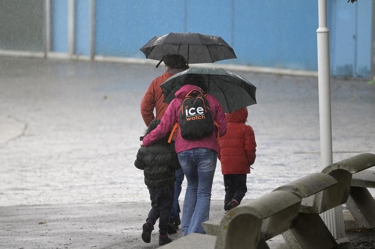 Un grupo de persoas camiña polo paseo marítimo da Coruña mentres chove. M. Dylan - Europa Press 
