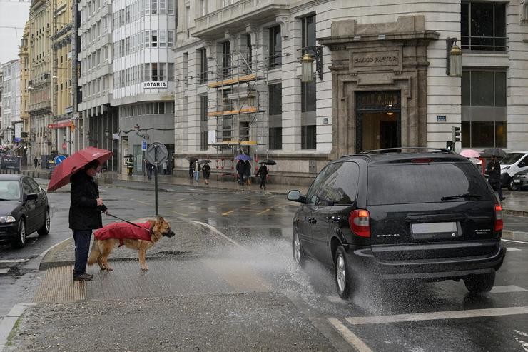 Unha persoa espera para cruzar co seu can nun paso de peóns da Coruña, Galicia (España). M. Dylan - Europa Press / Europa Press