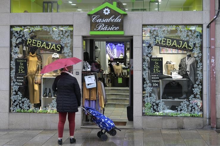 Unha muller na porta dun comercio en Arteixo, A Coruña. M. Dylan - Europa Press 