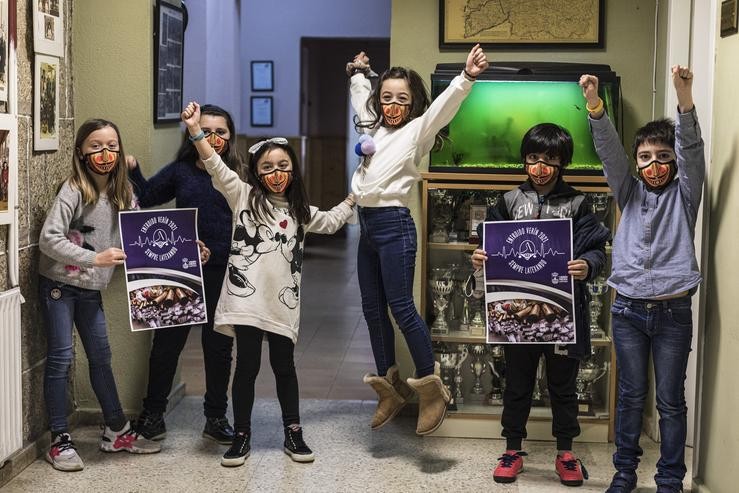 Cativas e cativos coas máscaras e o cartel da campaña de Entroido 2021. Foto: Concello de Verín