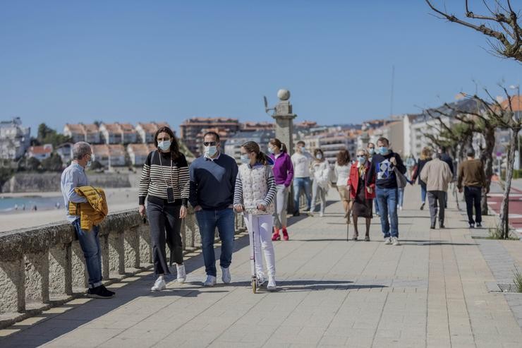 Varias persoas camiñan por un paseo marítimo en Sanxenxo, Pontevedra, Galicia (España), a 21 de marzo de 2021. Beatriz Ciscar - Europa Press 