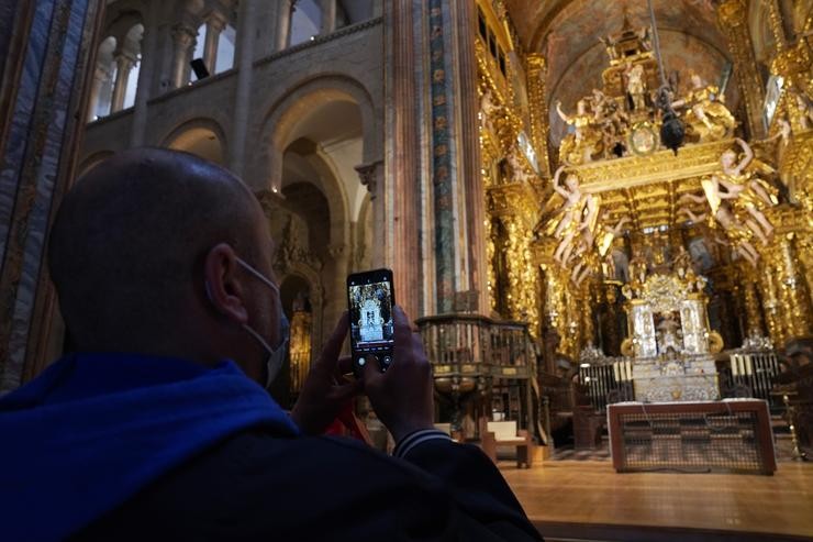 Un turista toma fotos no interior da Catedral de Santiago 