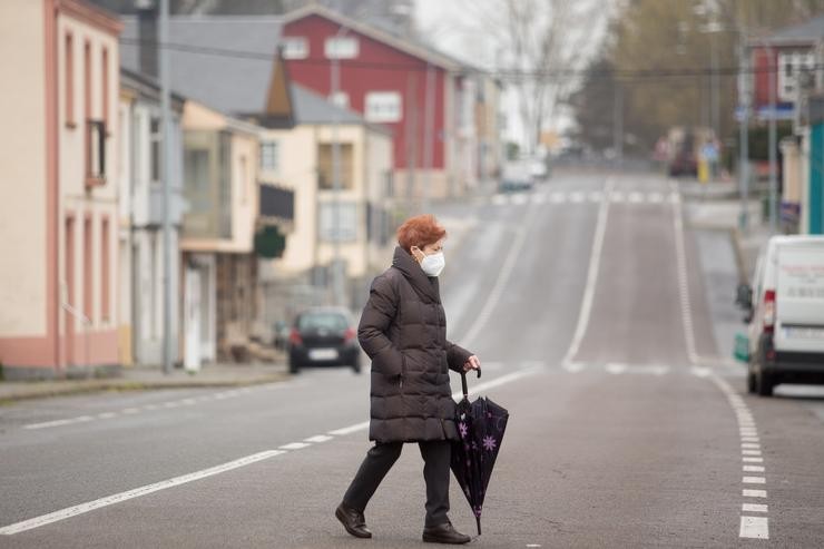 Unha muller cruza a Rúa Cabaleiros de Santiago, principal viaria da localidade en Paraleda, Lugo, Galicia. Carlos Castro - Europa Press