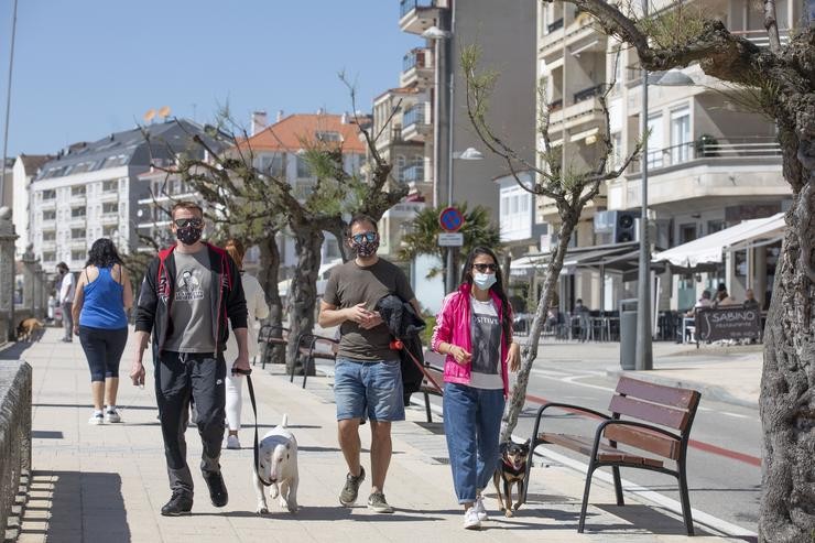 Varias persoas pasean polo Paseo Marítimo de Sanxenxo, en Pontevedra, Galicia (España), a 27 de marzo de 2021. O subcomité clínico mantén o nivel alto de restricións no concello de Sanxenxo, o que leva que a hostalaría só pode servir. Beatriz Ciscar - Europa Press 