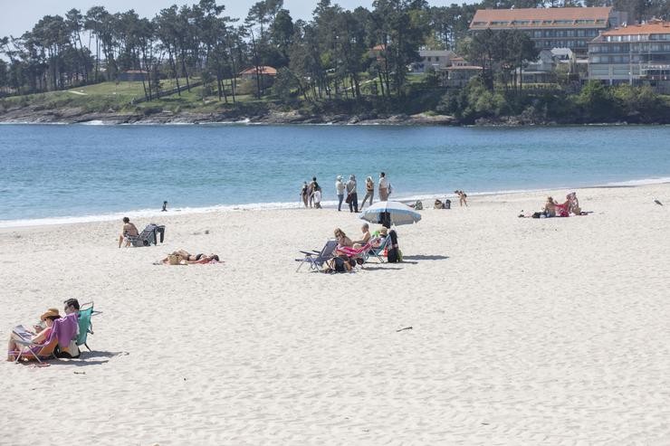 Varias persoas na praia de Sanxenxo, en Pontevedra, Galicia (España), a 27 de marzo de 2021. O subcomité clínico mantén o nivel alto de restricións no concello de Sanxenxo, o que leva que a hostalaría só pode servir nas terrazas e. Beatriz Ciscar - Europa Press