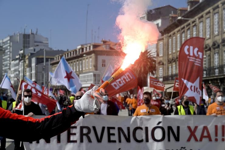 Decenas de persoas con bandeiras de sindicatos e fume durante unha manifestación convocada por varios sindicatos "en defensa do emprego, por un futuro industrial, contra a represión sindical en Alu Ibérica", na Coruña / M. Dylan - Europa Press. / Europa Press