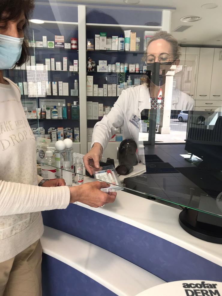 Unha farmacéutica entrega un test a unha muller / COLEXIO OFICIAL DE FARMACÉUTICOS DE OURENSE. / Europa Press