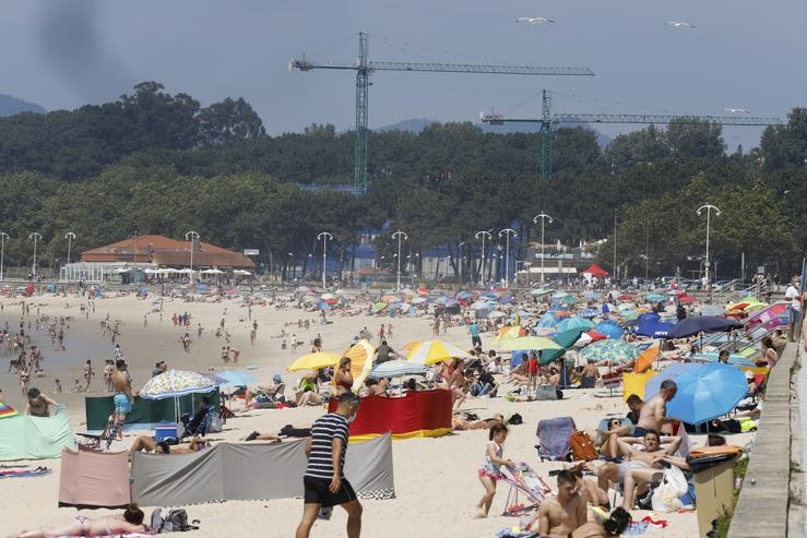 Numerosas persoas báñanse e toman o sol na praia de Samil, en Vigo 