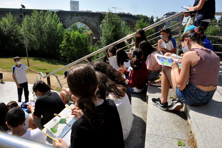 Un grupo de alumnos dun colexio debuxa preto da Ponte Romana en Ourense.. Rosa Veiga - Europa Press 