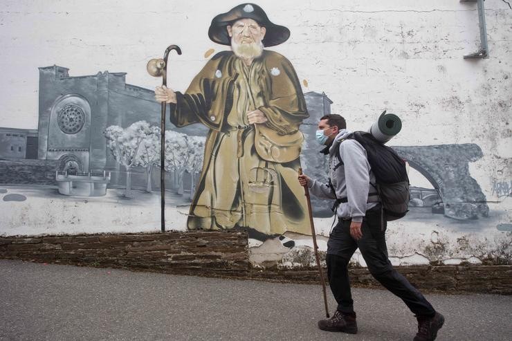 Gabriel, un peregrino madrileño que realiza por segunda vez o Camiño de Santiago e pasa por diante do mural do Zapatones, na ruta do Camiño de Santiago francés. Carlos Castro - Europa Press / Europa Press / Europa Press