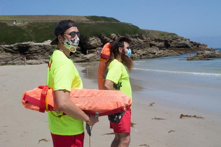 Arquivo - Dous socorristas protexidos con máscara vixían a Praia da Rapadoira en Foz, na comarca da Mariña, Lugo, Galicia (España), a 9 de xullo de 2020. O pasado 5 de xullo a Xunta ordenou o peche ata mañá 10 de xullo dos accesos do. Carlos Castro - Europa Press - Arquivo