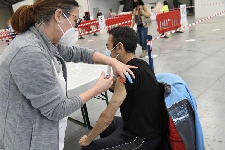 Unha sanitaria vacina contra a covid-19 un home no Instituto Feiral de Vigo (Ifevi) 