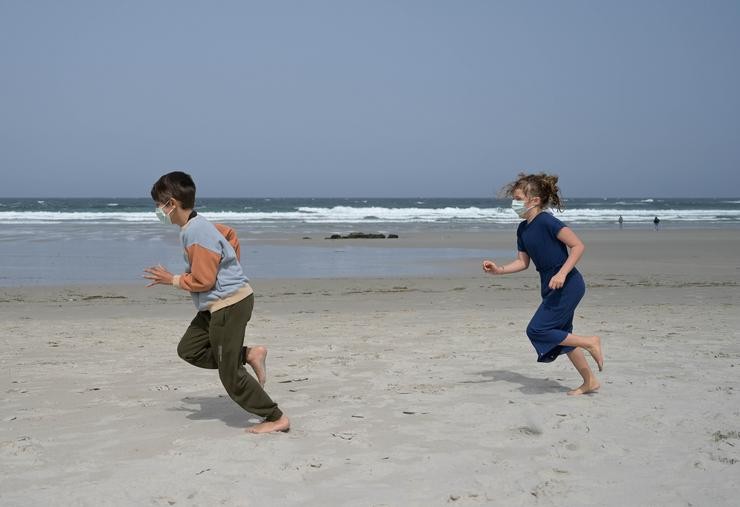 Cativos con máscaras para protexerse contra a covid-19 na praia das Salseiras, a 3 de abril de 2021, no concello da Laracha, A Coruña 