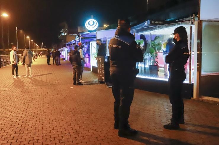 Dous axentes de Policía Local pasean polo Porto de Sanxenxo para informar en cada un dos locais de lecer nocturno sobre as novas medidas Covid, en Sanxenxo, a 3 de xullo de 2021, en Pontevedra, Galicia (España). As autoridades poden chegar a mul. Marta Vázquez Rodríguez - Europa Press 