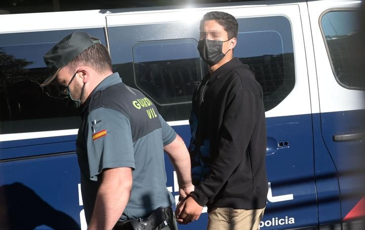 Un dos investigados pola morte de Samuel Luiz acode, esposado e acompañado dun axente da Policía Nacional, ao  Xulgado de Instrución número 8 da Coruña, a 16 de xullo de 2021.. M. Dylan - Europa Press / Europa Press