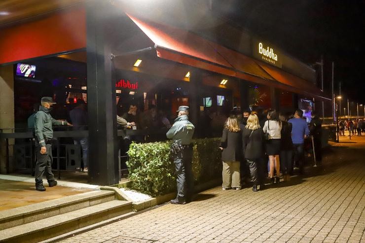 Dous axentes de Garda Civil pasan polos locais de lecer nocturno do Porto de Sanxenxo para informar das medidas Covid, en Sanxenxo. Marta Vázquez Rodríguez - Europa Press