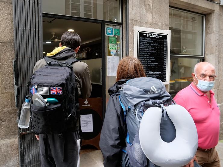Dous peregrinos fronte a un local de hostalaría o pasado 31 de xullo de 2021, en Santiago de Compostela.. César Arxina - Europa Press / Europa Press