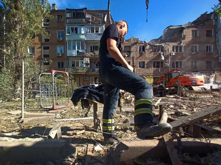 Un bombeiro que participa nas labores de rescate fronte o edificio destruído en Mikolaiv / Miriam González