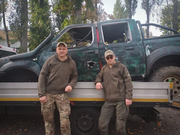 Os voluntarios bielorrusos Vazdim e Mark cun dos coches do Batallón Kastus Kalinouski que estivo na fronte de batalla / Miriam González