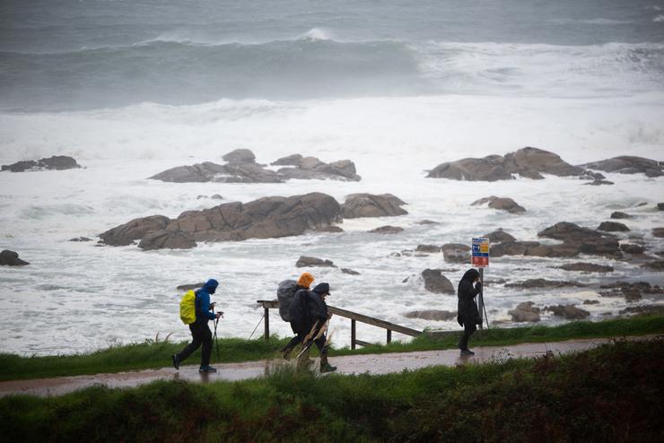 Varios peregrinos realizan o Camiño de Santiago, a pesar do temporal, na zona de Santa Maria de Oia ata Cabo Silleiro 