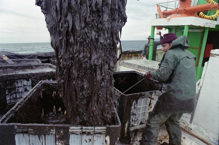Un barco pesqueiro de cerco utiliza as súas redes para tratar de sacar a maior cantidade de chapapote do mar tras o afundimento do Prestige. / Álvaro Ballesteros