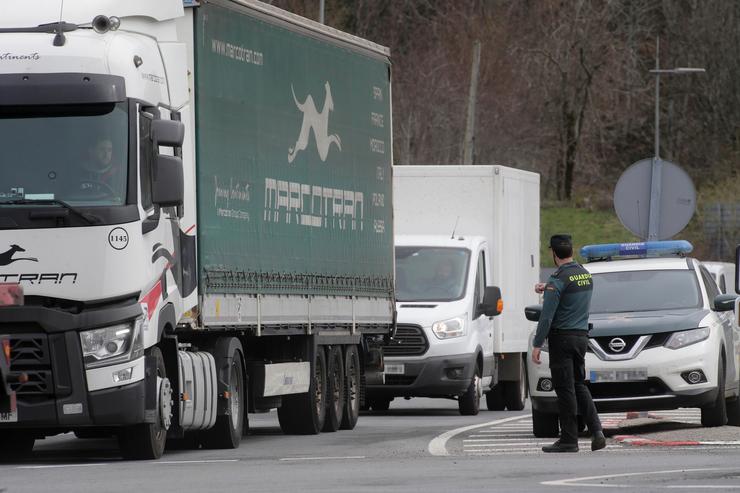 Un axente da Garda Civil dirixe o tráfico de camións en dirección á Autovía A6. Carlos Castro - Europa Press - Arquivo