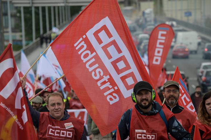Varias persoas con bandeiras de CCOO durante unha manifestación con motivo da terceira xornada da folga do sector siderometal, a 18 de maio de 2022, en Oleiros 