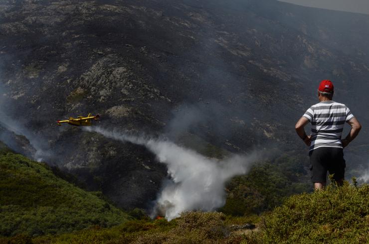 Un veciño de Senderiz en Lobeira observa un hidroavión traballar no incendio forestal na Serra do Leboreiro, no parque natural de Baixa Limia e Serra do Xurés 