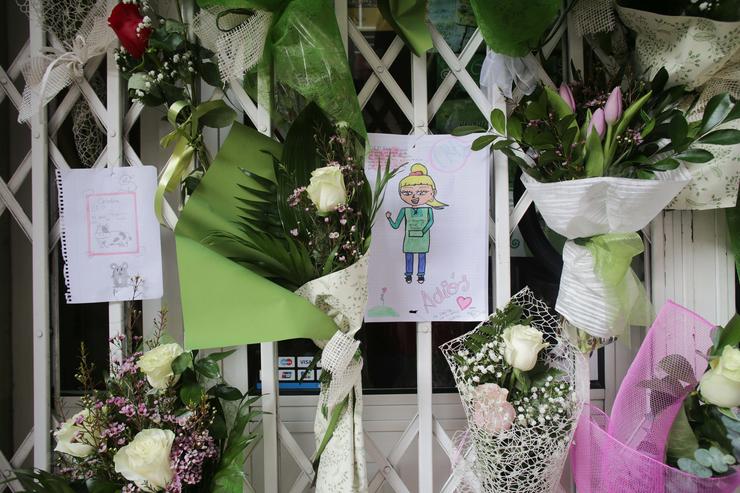 Un debuxo e varias flores colgadas na tenda de alimentación onde traballaba a muller de 42 anos morta a coiteladas en Lugo / Carlos Castro