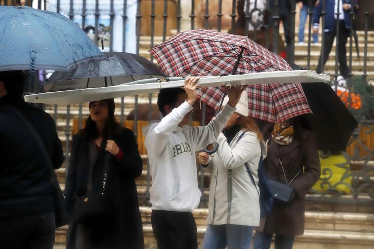 Varias persoas resgárdanse con paraugas. A 9 de decembro de 2022 en Málaga, Andalucía. A borrasca deixa xa máis de 60 litros na provincia de Málaga e a Axencia Estatal de Meteoroloxía, Aemet rebaixa a amarelo o aviso laranxa por fortes choivas en. Álex Zea - Europa Press 