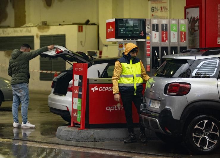 Unha persoa bota gasolina do chafariz dunha gasolineira