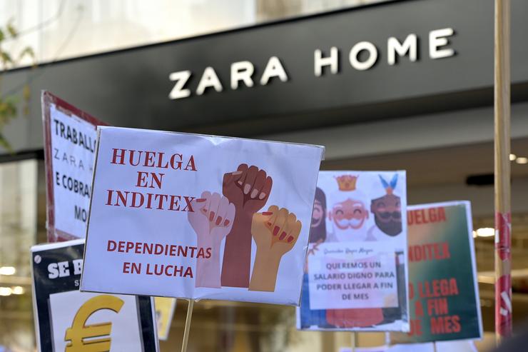Traballadores maniféstanse con pancartas fronte unha tenda Zara Home durante a primeira xornada de folga das tendas de Inditex na Coruña 