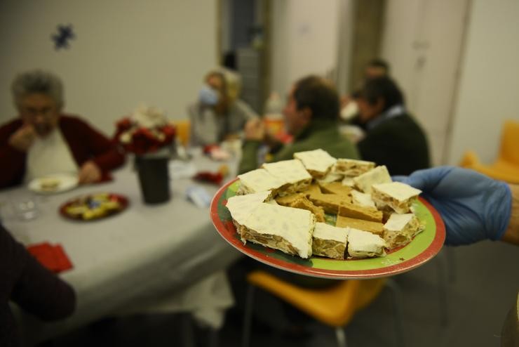 Un voluntario sostén un prato para servir no Fodar Do Transeunte, durante a noite de Fin de Ano, a 31 de decembro de 2021, en Ourense. Rosa Veiga - Europa Press 