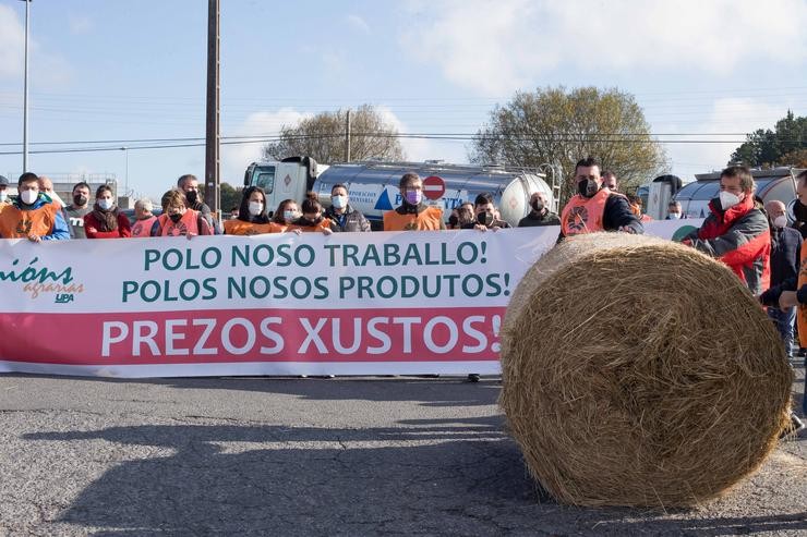 Arquivo - Varias persoas suxeitan a pancarta principal da manifestación en defensa duns prezos xustos para a produción de leite, ante a planta de Larsa, a 16 de novembro de 2021, en Robra, Outeiro de Rei, Lugo, Galicia, (España). Apoiados por. Carlos Castro - Europa Press - Arquivo / Europa Press