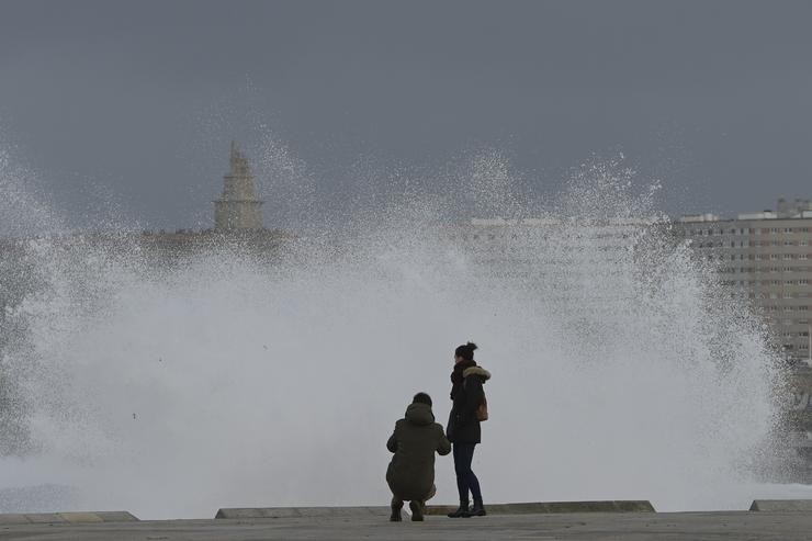 Dúas persoas observan as ondas que rompen na zona das Escravas, na Coruña.. M. Dylan - Europa Press 