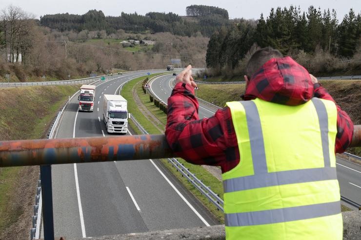 Un membro dun piquete insulta e fai xestos aos camións que pasan en dirección A Coruña escoltados pola Garda Civil, durante o cuarto día de paros no sector dos transportes, a 17 de marzo de 2022, en Baralla, Lugo 