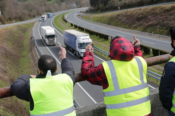 Dous membros dun piquete insultan e fan xestos aos camións que pasan en dirección A Coruña escoltados pola Garda Civil, durante o cuarto día de paros no sector dos transportes, a 17 de marzo de 2022, en Baralla, Lugo, Galicia (España). L. Carlos Castro - Europa Press