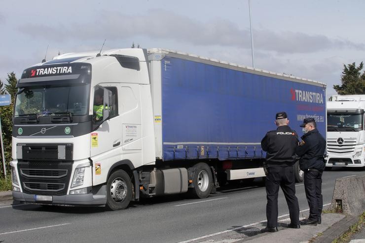 Dous axentes de Policía Nacional observan os camións parados na beiravía nun dos accesos ao Polígono de Ou CEAO, nunha folga indefinida do transporte de mercadorías, a 14 de marzo de 2022, en Lugo, Pontevedra (España). O paro, convocado a nivel n. Carlos Castro - Europa Press 