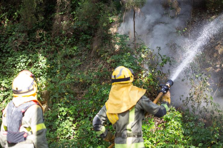 Dous bombeiros nun incendio forestal na parroquia de Cubilledo, no concello de Baleira, comarca da Fonsagrada, a 18 de agosto de 2021 