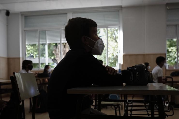 Un neno con máscara nunha aula dun colexio 