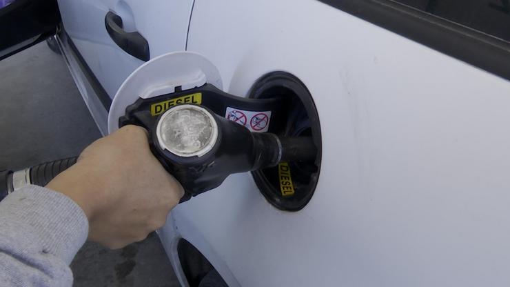 Persoa enchendo combustible nunha gasolineira 