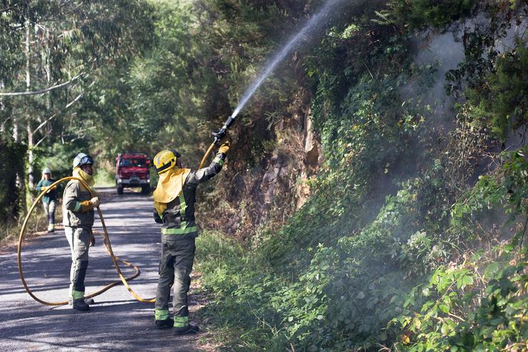 Dous bombeiros nun incendio forestal na parroquia de Cubilledo, no municipio de Baleira, comarca da Fonsagrada, a 18 de agosto de 2021, en Lugo / Carlos Castro - Europa Press - Arquivo