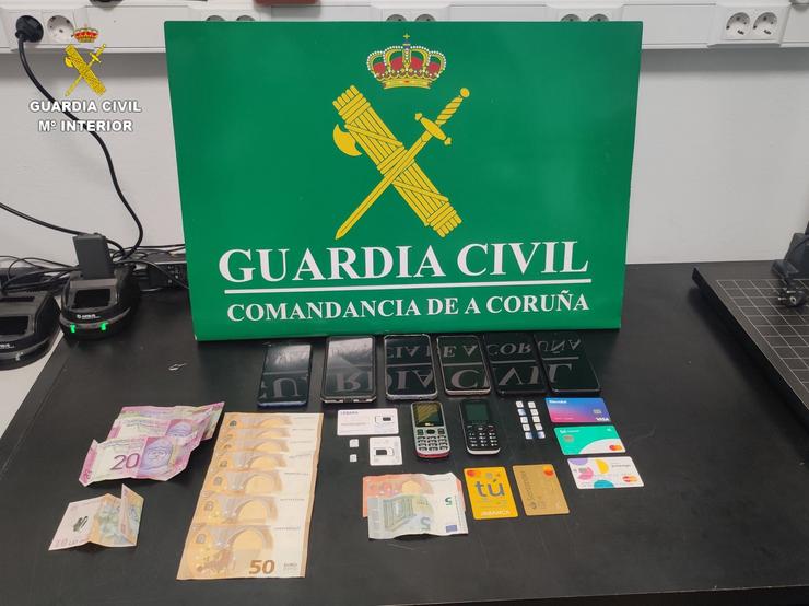 Efectos incautados na operación na que foron detidas tres persoas e investigada outra por estafa e pertencencia a grupo criminal en Carballo (A Coruña). GARDA CIVIL 