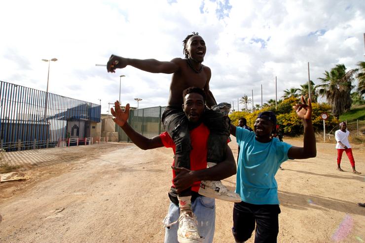 Varios migrantes diríxense ao Centro Temporal de Inmigrantes (CETI), mentres celebran o salto do valo de Melilla, a 24 de xuño de 2022, en Melilla (España).. ANTONIO RUIZ - Europa Press