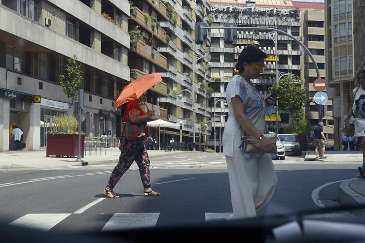 Dúas persoas camiñan por unha vía en plena onda de calor, a 12 de xullo de 2022, en Ourense.. Rosa Veiga - Europa Press