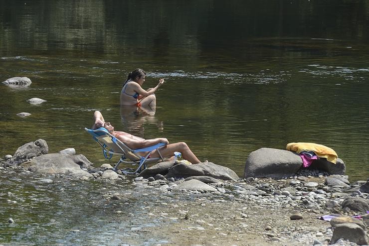 Dúas persoas na beira do río Miño, a 12 de xullo de 2022, en Ourense.. Rosa Veiga - Europa Press 