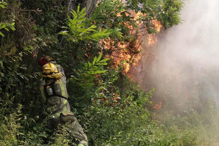 Un membro das Brigadas de Reforzo en Incendios Forestais (BRIF) realiza labores de extinción nas inmediacións dun incendio, a 15 de xullo de 2022, en Samos / Carlos Castro