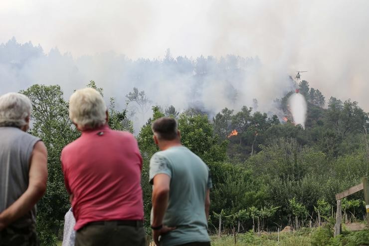 Tres homes observan un incendio, a 15 de xullo de 2022, en Quiroga, Lugo 